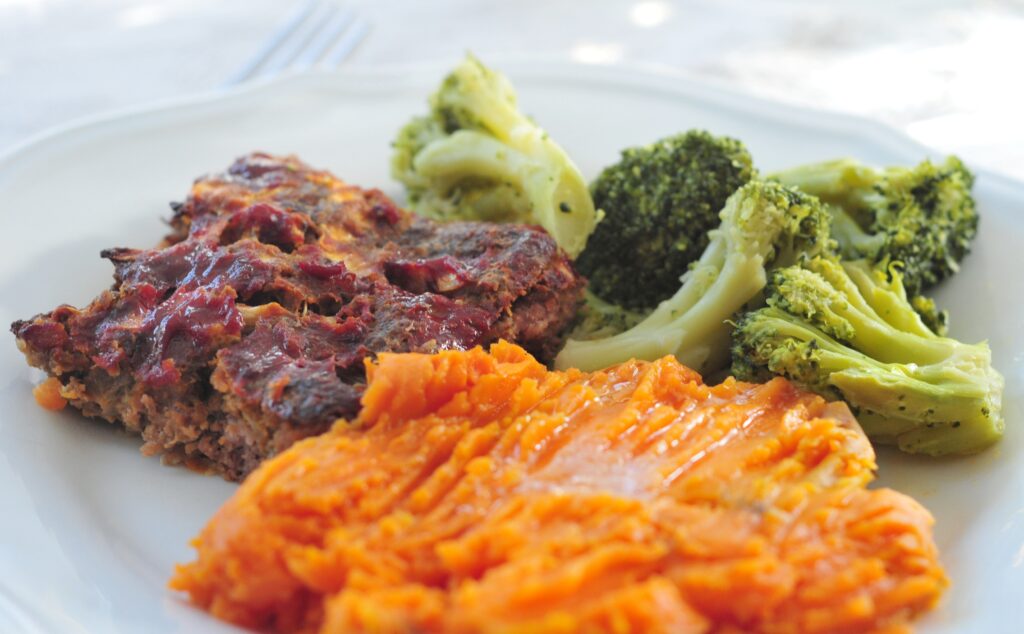 close up of plate with meatloaf, sweet potatoes, and broccoli