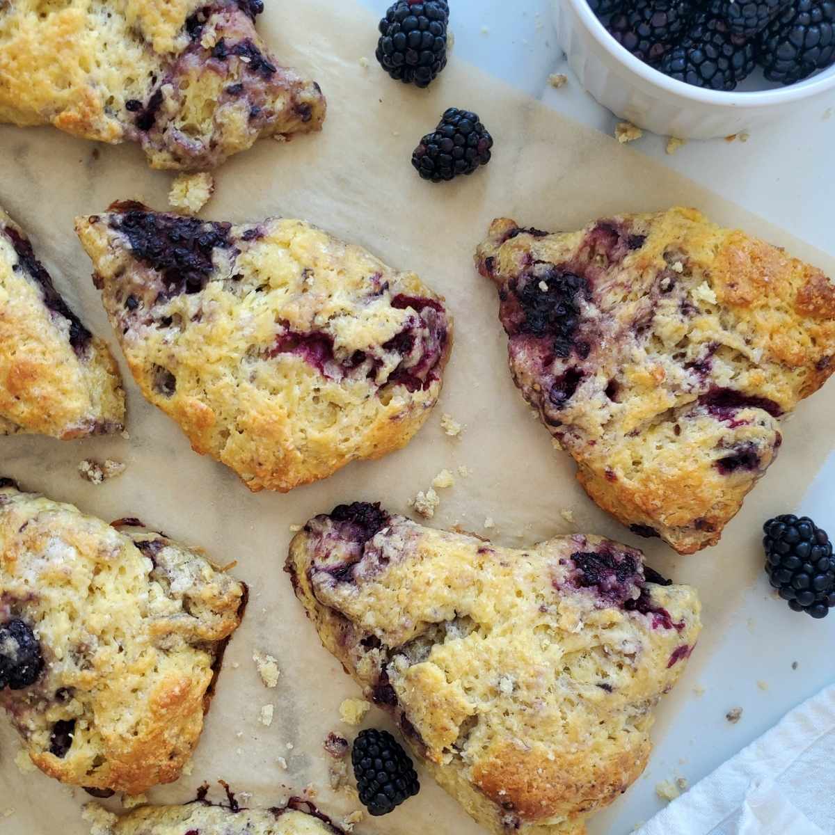blackberry sourdough scones with blackberries on parchment paper