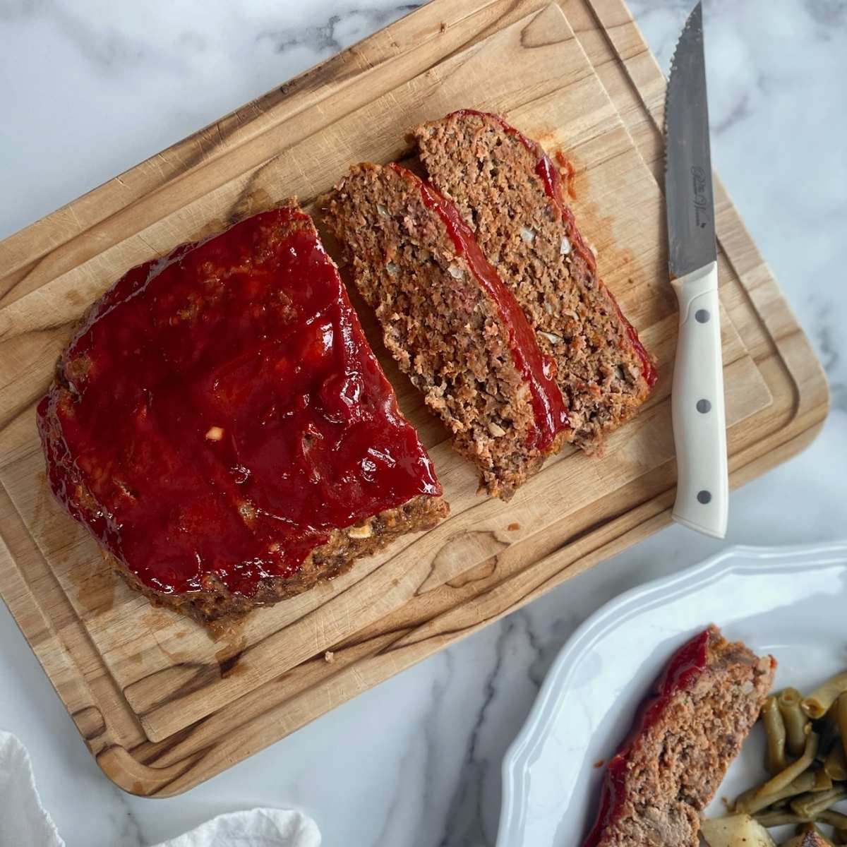 meatloaf and knife on a wooden cutting board