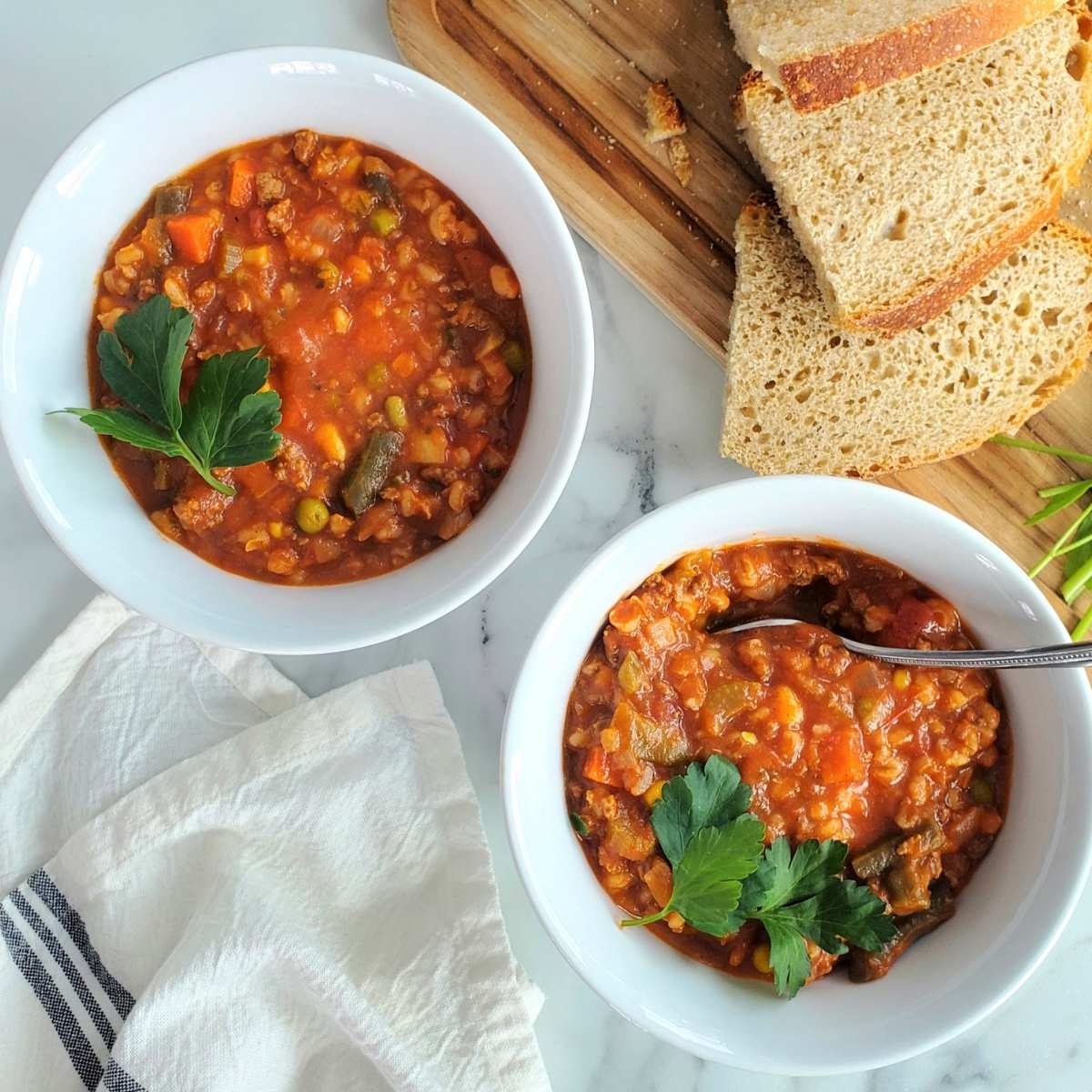 beef and barley soup in a bowl with parsley
