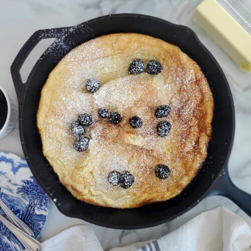 sourdough dutch baby with blackberries in a cast iron skillet