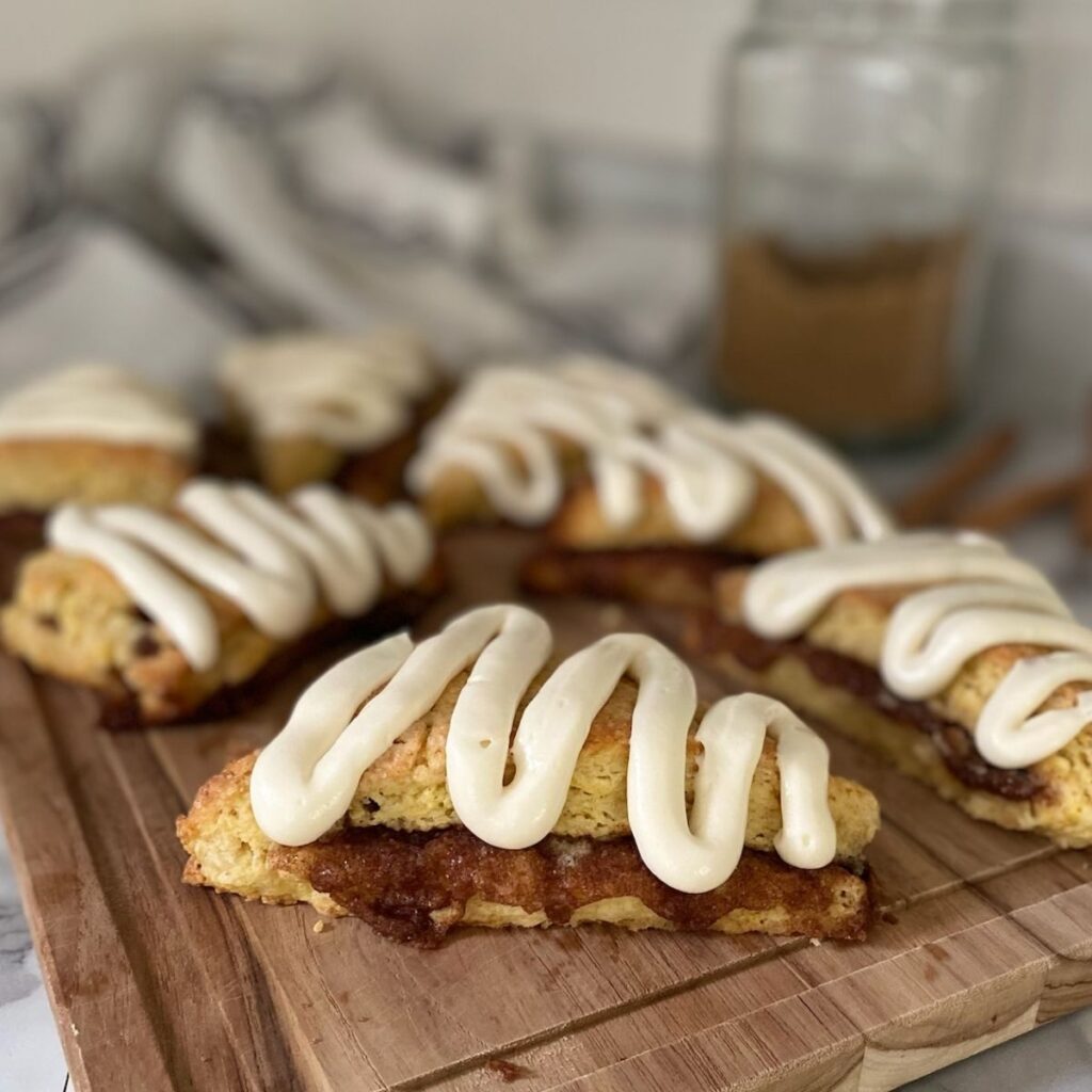 cinnamon roll sourdough scone on a wooden cutting board