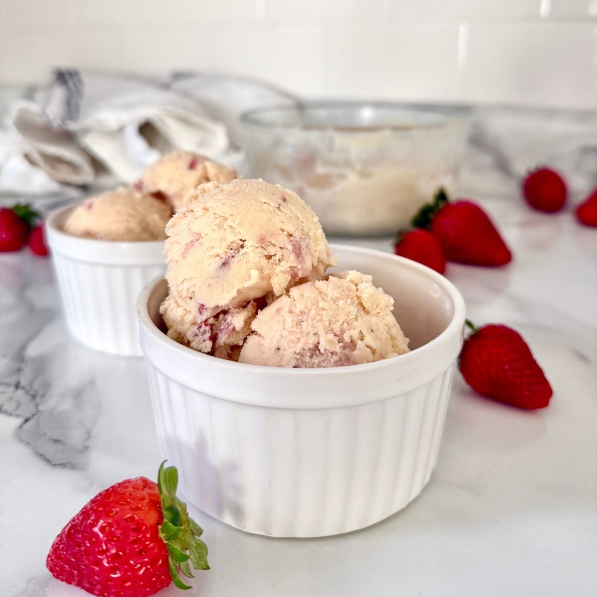 strawberry raw milk ice cream in a ramekin with strawerries