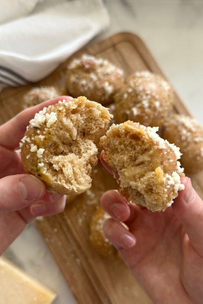 fresh milled sourdough garlic knots with parmesan on a cutting board