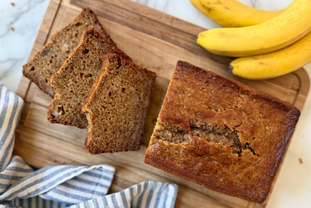 slices of fresh milled einkorn banana bread on a wooden cutting board
